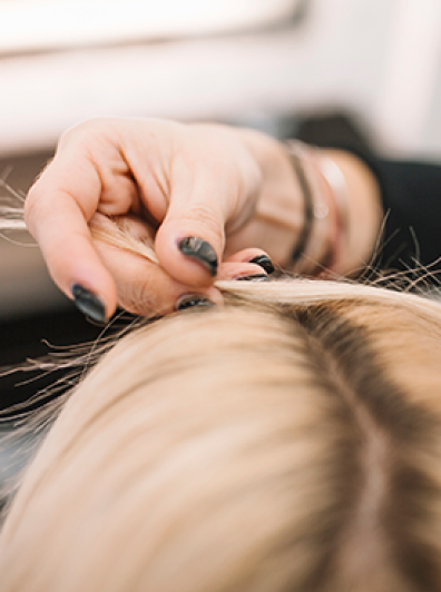 Close-up of stylist parting blonde hair for color service