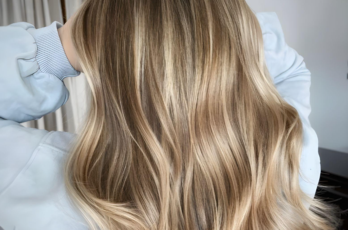 Full head babylights on medium brown hair with soft blonde highlights for a natural, radiant look in San Diego.