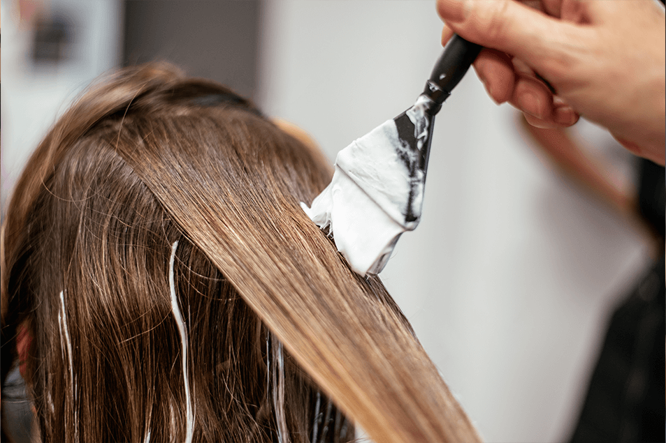 Hair colorist applying balayage lightener for a soft, blended highlight effect