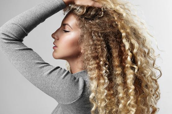 Curly hair with subtle partial highlights and blended brightness