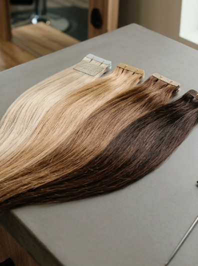 Premium tape-in hair extension wefts laid on Salotto Salon counter.