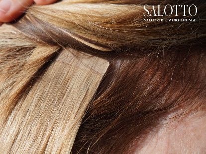 Close-up of tape-in hair extension bonded to blonde natural hair section.