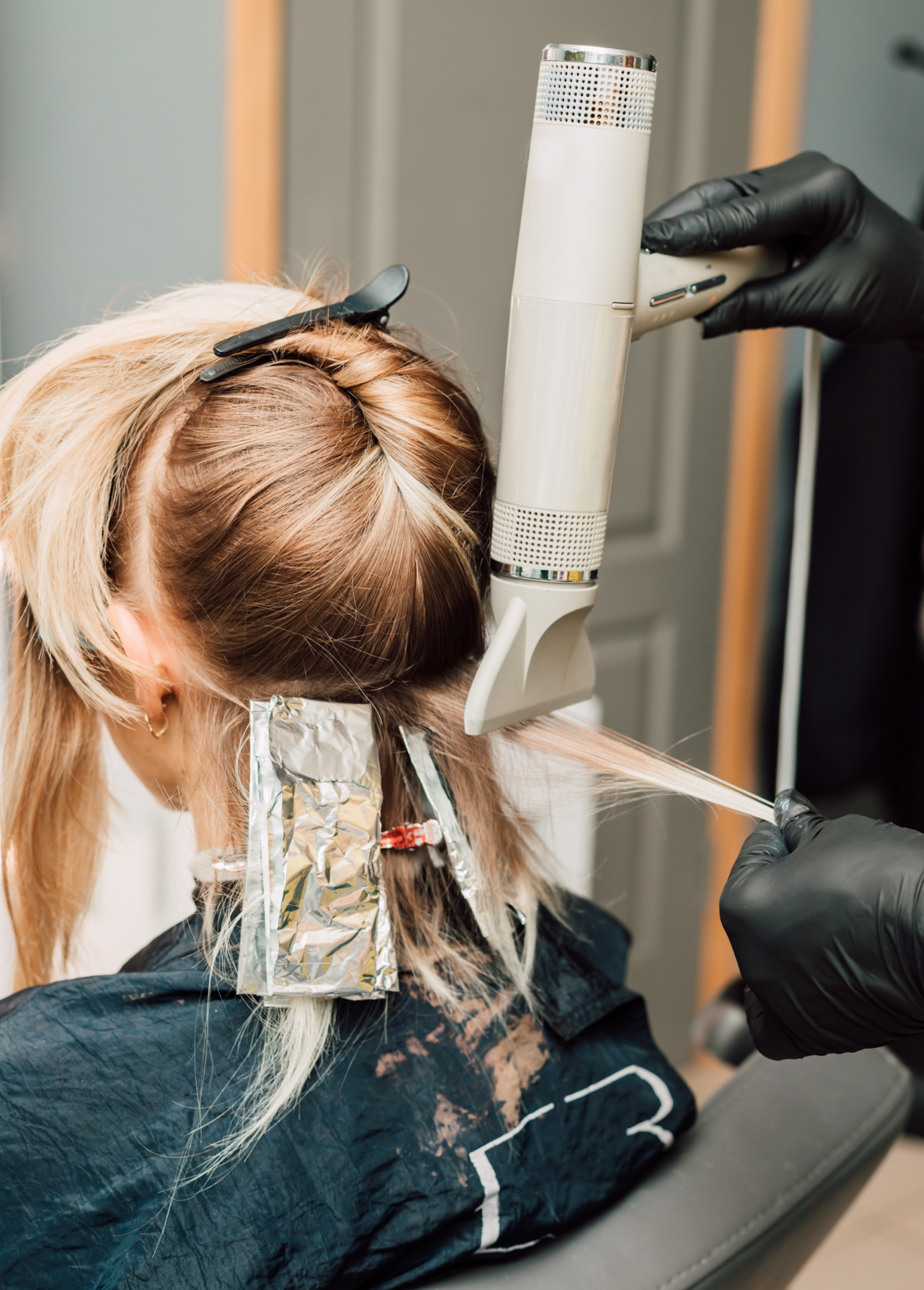 Colorist applying balayage to blonde hair