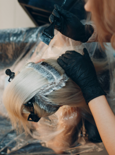 Stylist applying lightener for blonde hair color
